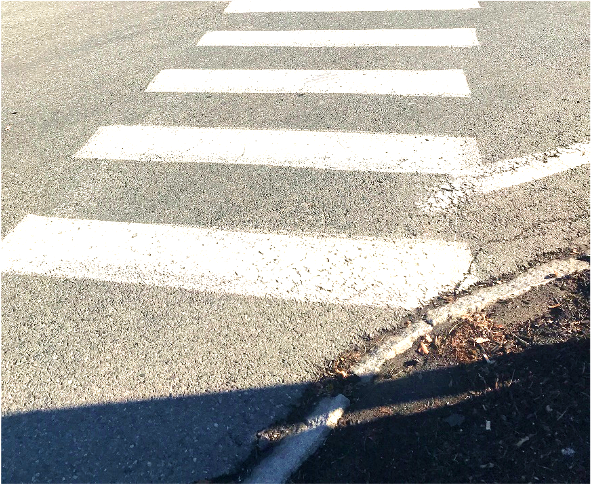 Figure 13 - Lack of Pedestrian Facilities on Southwest Intersection Corner leading to Gleasondale Road (Route 62) Crosswalk. Image is an aerial close-up of where the crosswalk meets the bed of mulch and vegetation, showing that the corner does not include sidewalks or any other pedestrian accommodations.